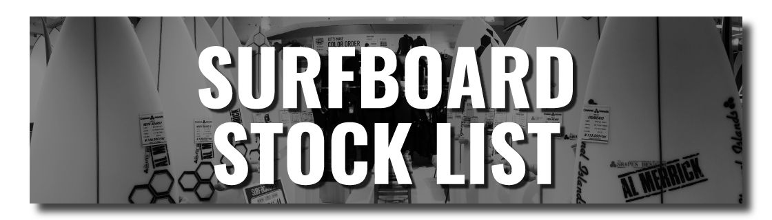 Banner showing the words SURFBOARD STOCK LIST over a row of surfboards in a shop window.