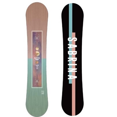 Two snowboards standing upright side by side: the left board has a wood-grain finish with a framed graphic in the center; the right board is black with a pale pink vertical stripe and the word 'SABRINA' written along the stripe in white.