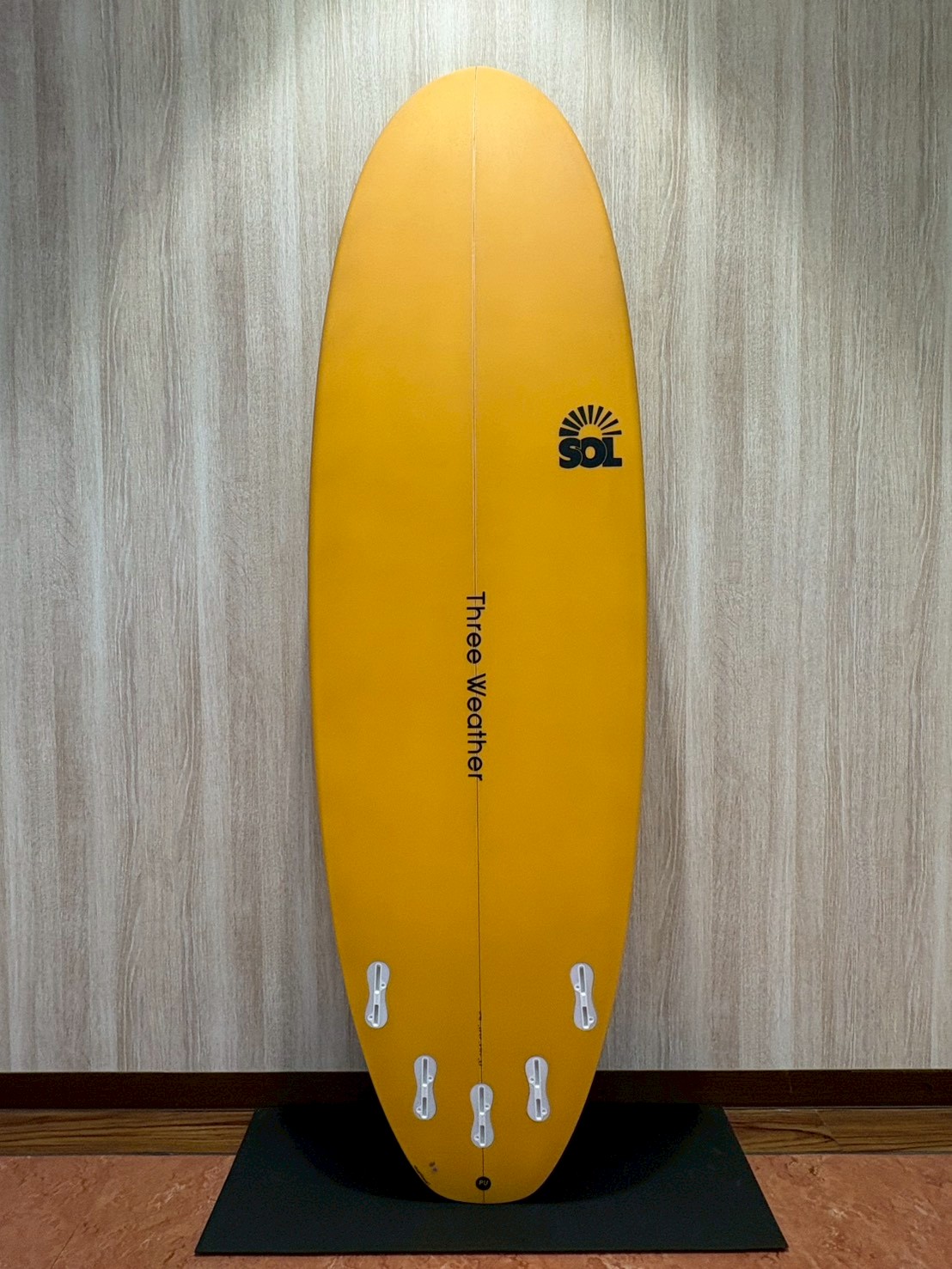 LINE_ALBUM_2026 TW_260422_6 - SHOP NEWS | ムラサキスポーツオンラインストア 通販 Bright yellow surfboard standing upright with six tail fins, SOL logo, and 'Three Weather' text down the center.