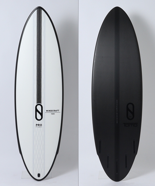 s-MINDCRAFT_PRO_1 - SHOP NEWS | ムラサキスポーツオンラインストア 通販 Two surfboards standing upright against a white wall: a white Mindcraft Pro Flex board on the left and a black Tomo board on the right.