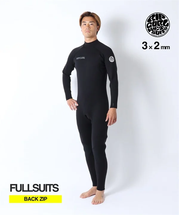 Black full-body wetsuit with back zip worn by a man, Rip Curl branding on chest and sleeve, white studio background.