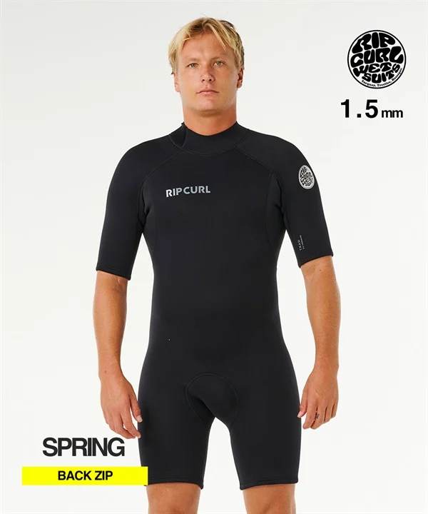 Male model wearing a black Rip Curl 1.5mm back-zip wetsuit; full-body front view on a white backdrop.